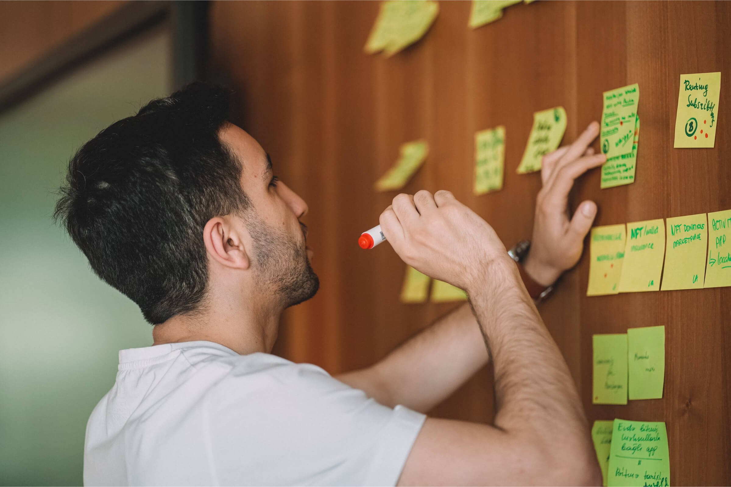 Ein Mann beschriftet mit Filzstift Postits